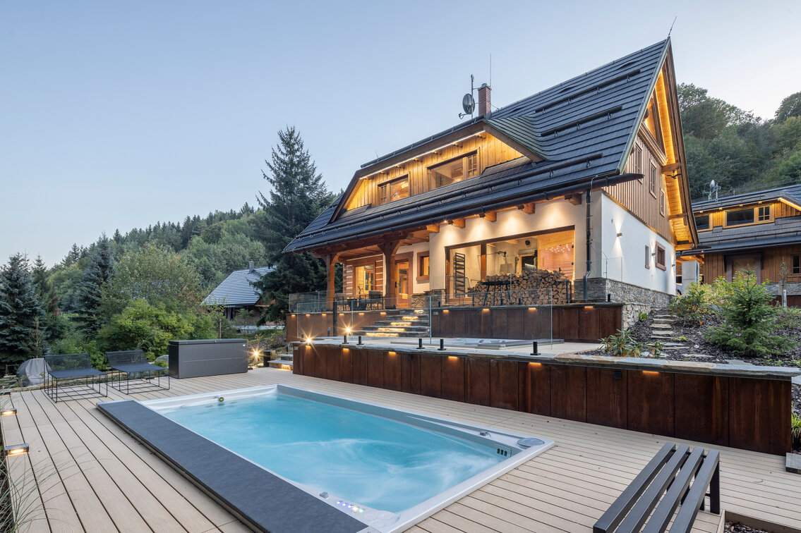 Celoroční bazén USSPA Swim Spa XL a automatickým termokrytem zabudovaný do terasy u luxusní chalupy k pronájmu