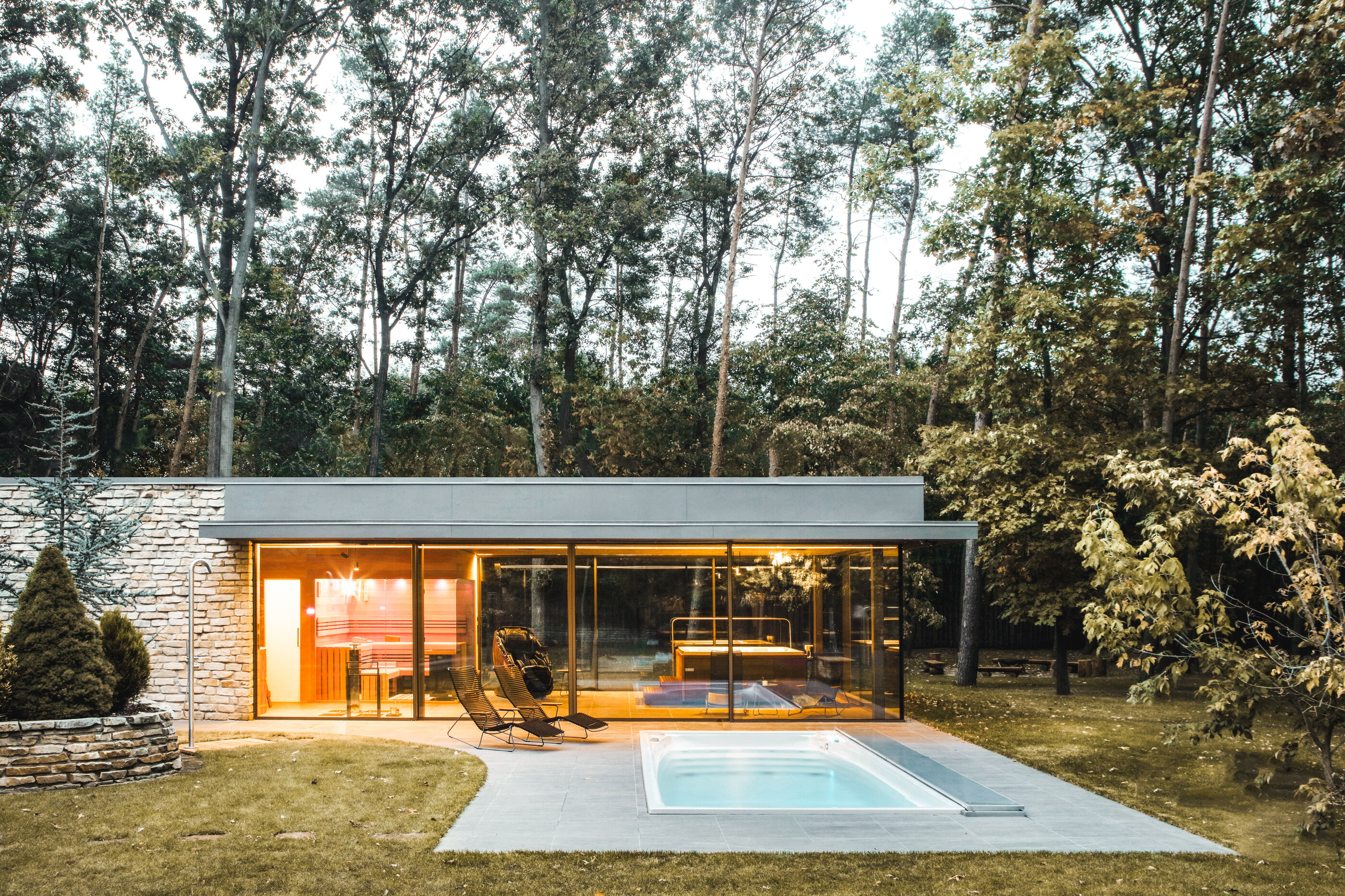 Venkovní celoroční bazén Swim Spa XL doplněn o vnitřní wellness zónu s vířivkou a saunou.