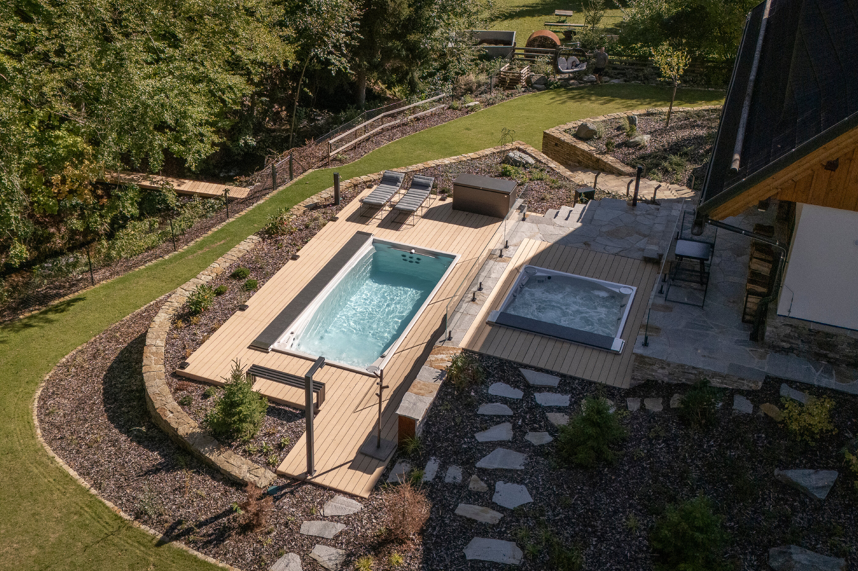 Celoroční bazén Swim Spa XL s protiproudem a luxusní vířivka Lounge iN zabudovaná do svažitého terénu 