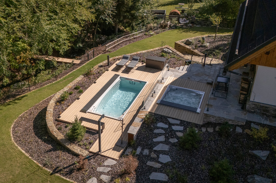 Celoroční bazén Swim Spa XL s protiproudem a luxusní vířivka Lounge iN zabudovaná do svažitého terénu 